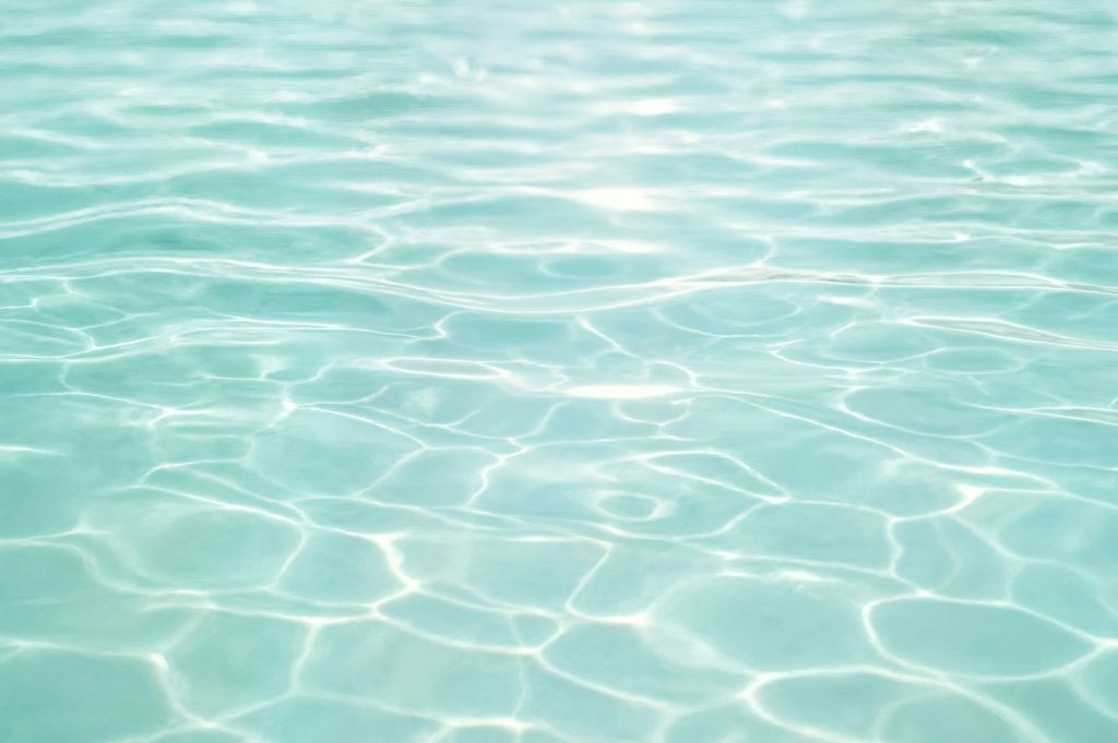 Crystal-clear pool water with sunlight reflections