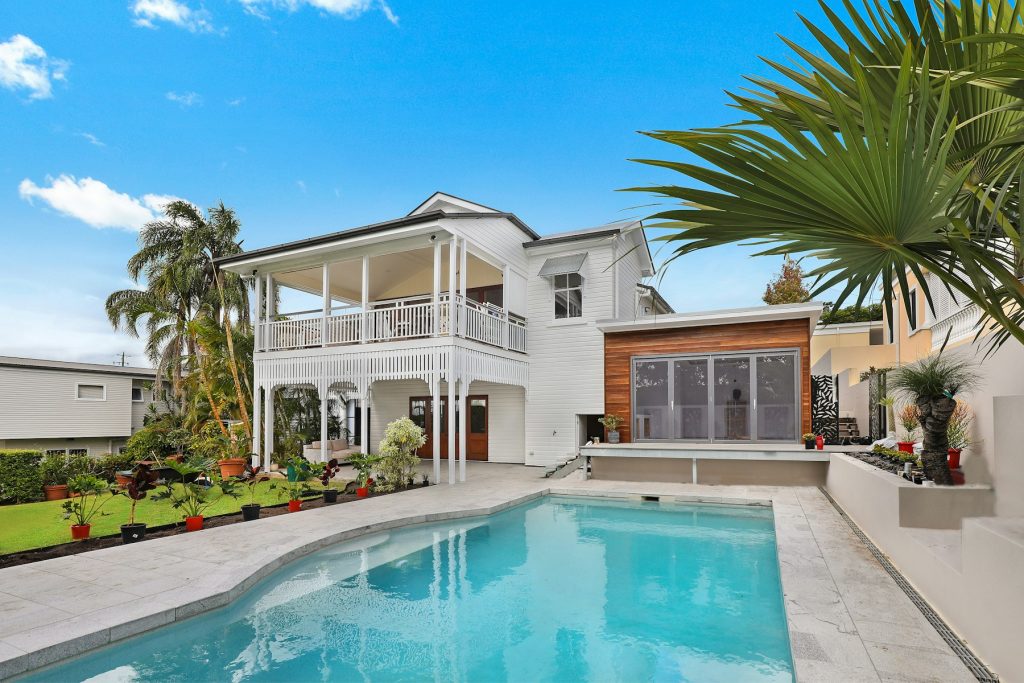 Residential pool behind a two-story home